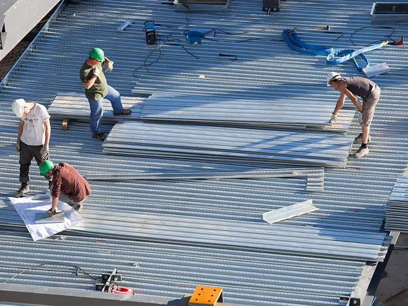 Ouvriers de Soulie CEA installant des bardages métalliques sur chantier à Lédergues,