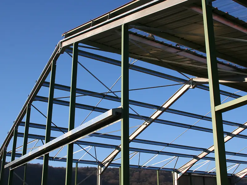 Ossature métallique de bâtiment agricole Soulie CEA à Lédergues, structure en acier vert sous ciel bleu,