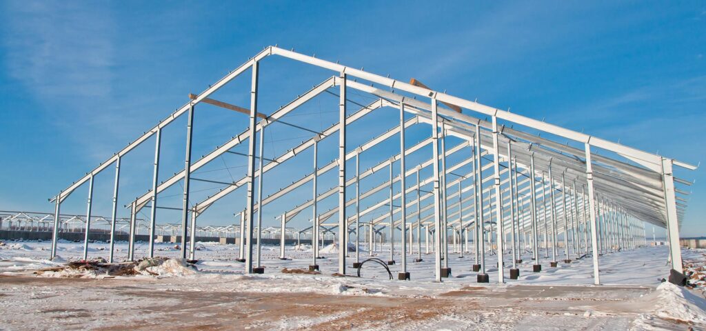 structure métallique Soulie CEA en construction sur terrain enneigé à Lédergues sous ciel bleu,