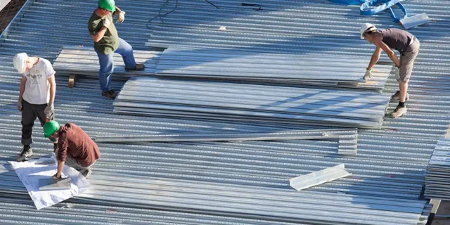 Ouvriers de Soulie CEA installant des bardages métalliques sur chantier à Lédergues,